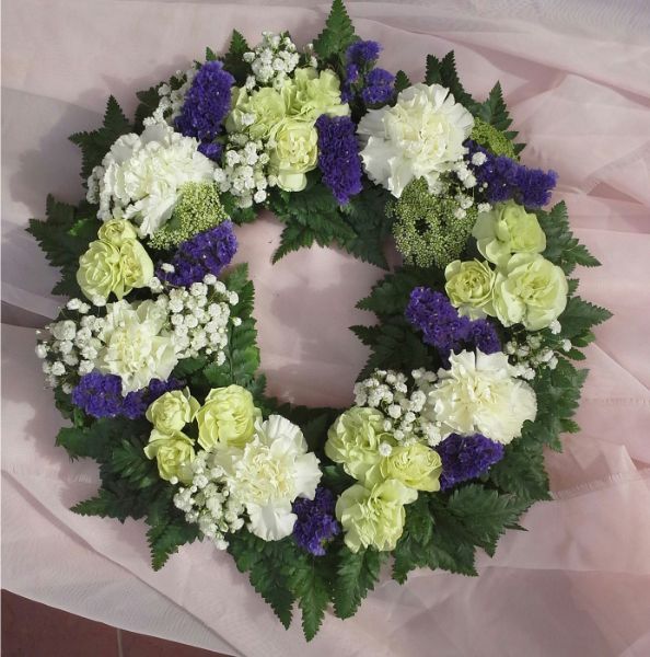 Valkoisista ja violeteista kukista solmittu hautaseppele