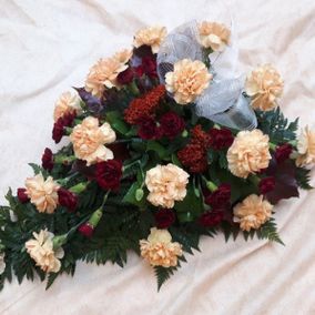 Erivärisistä kukista tehty hautajaiskimppu