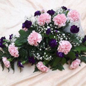 Vaaleanpunaisia ja violetteja kukkia hautajaiskimpussa