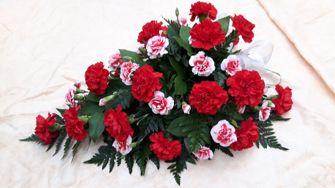 Punaisista kukista tehty kimppu haudalle