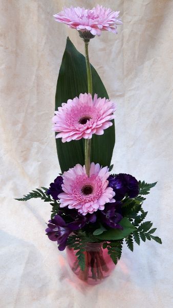 Vaaleanpunaisista ja violeteista kukista tehty kukka-asetelma